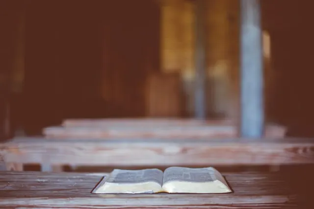 Open Bible on a wooden bench