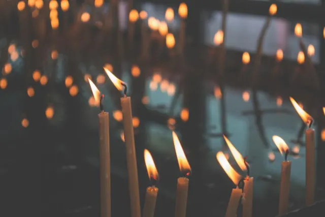 Rows of lit votive candles